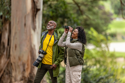 A couple on an outdoor walk and hike enjoying bird watching and photography.