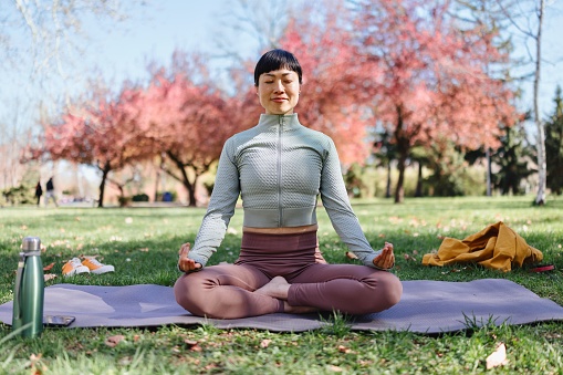 Woman meditating in the park on a beautiful day.