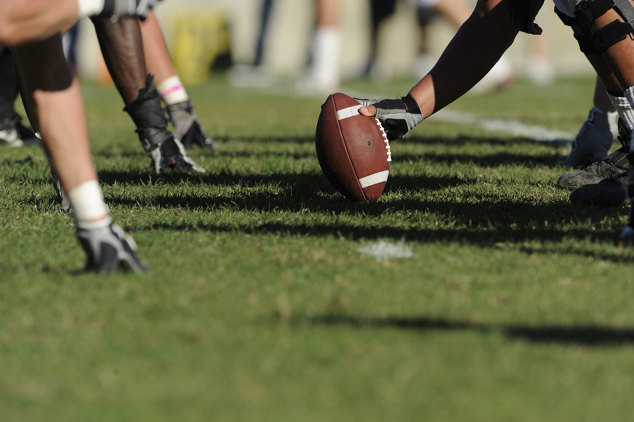 A football player gets ready to hike a football.